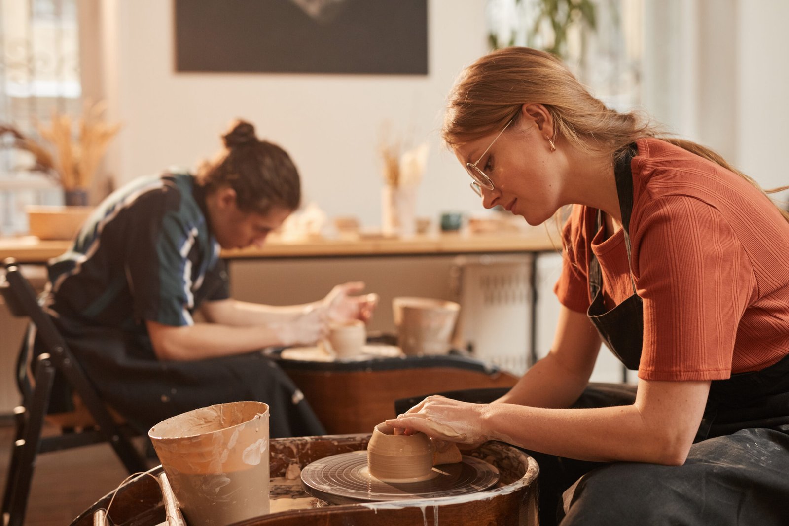 young woman making handmade pottery side view