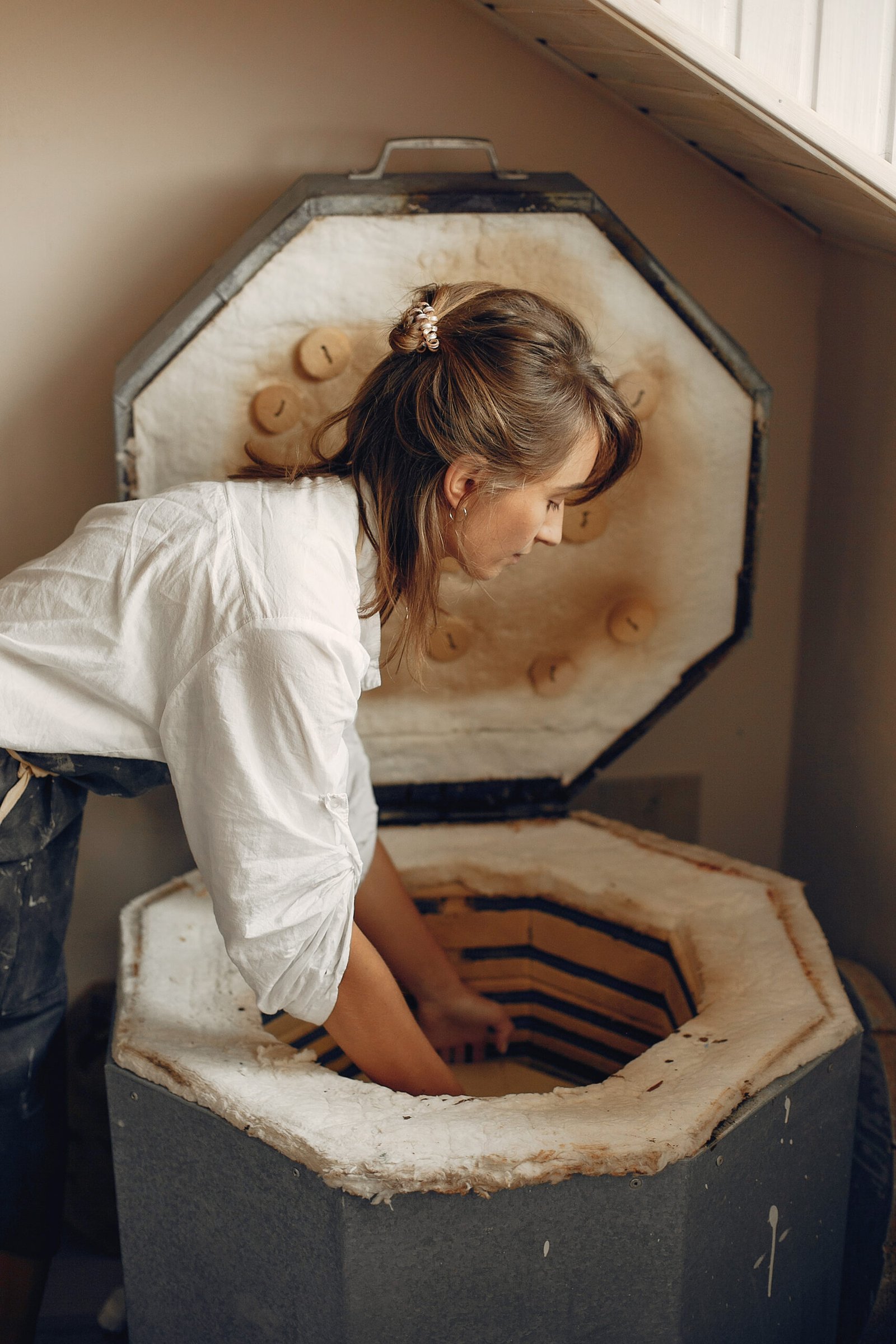 a young woman makes dishes in a pottery